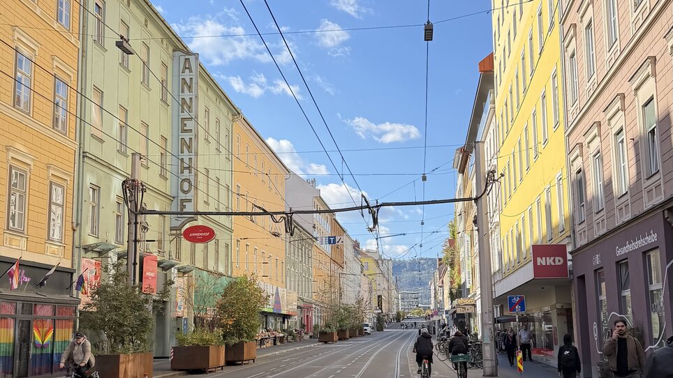 Bunte Häuser entlang einer Straße in Graz, Wolken und blauer Himmel. | © Graz Tourismus