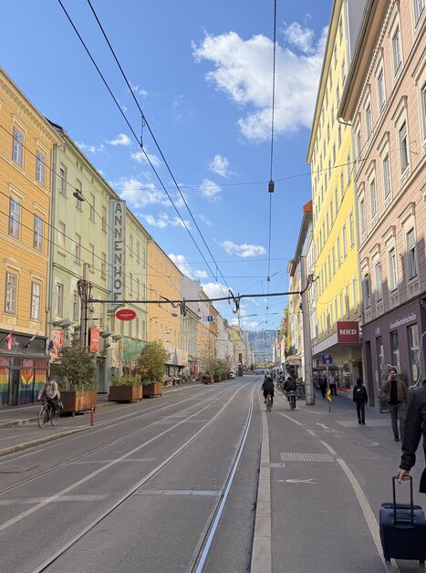 Edifici colorati lungo una strada a Graz, nuvole e cielo blu. | © Graz Tourismus