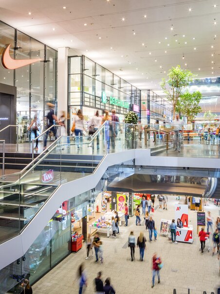 Tante persone che camminano all'interno di un centro commerciale. | © MURPARK