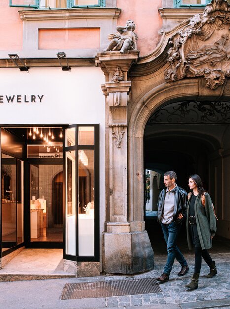 Couple walking in Graz in front of a jewelry store with a window display. | © Graz Tourismus