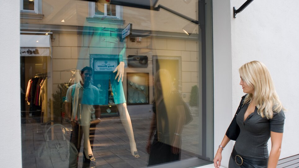 Woman looking at shop window with mannequin in Graz. | © Graz Tourismus - Hans Wiesenhofer