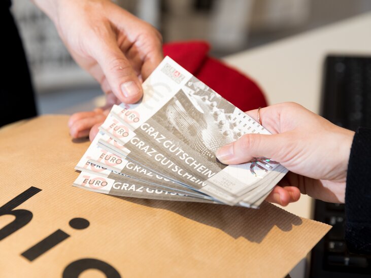 Person bezahlt mit GrazGutscheinen in einem Geschäft. | © Graz Tourismus - Harry Schiffer