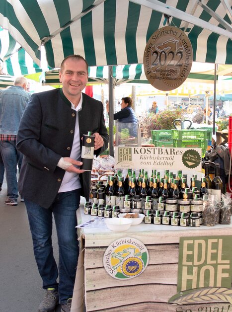 Man selling pumpkin seed oil at market in Graz. | © Edelhof