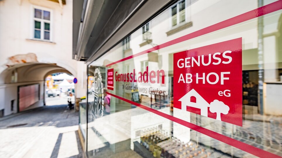 Window of a store with the sign "GenussLaden" and "Genuss ab Hof" in Graz. | © Gut Schlossberg