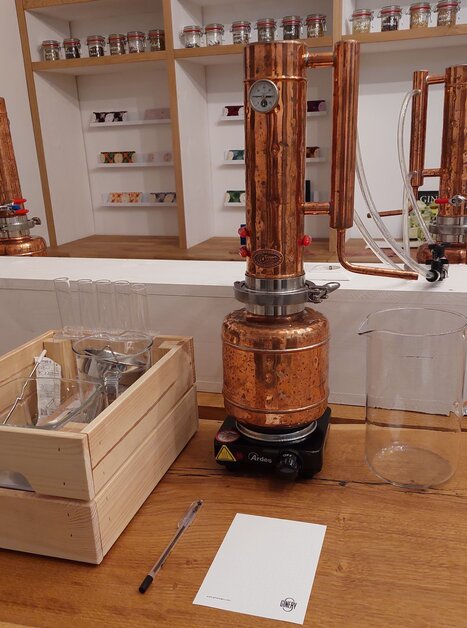 Eine Kupferdestille mit Glasbehältern und Zubehör im Hintergrund. | © The Ginery