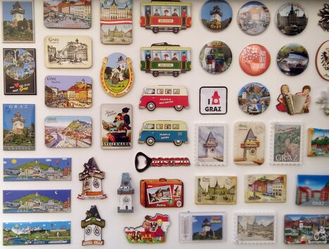 A collection of souvenirs and magnets featuring motifs from Graz, including the Graz Clock Tower. | © Raimund Illek