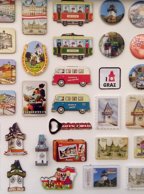 Una collezione di souvenir e magneti con motivi di Graz, incluso il Torre dell'Orologio di Graz. | © Raimund Illek
