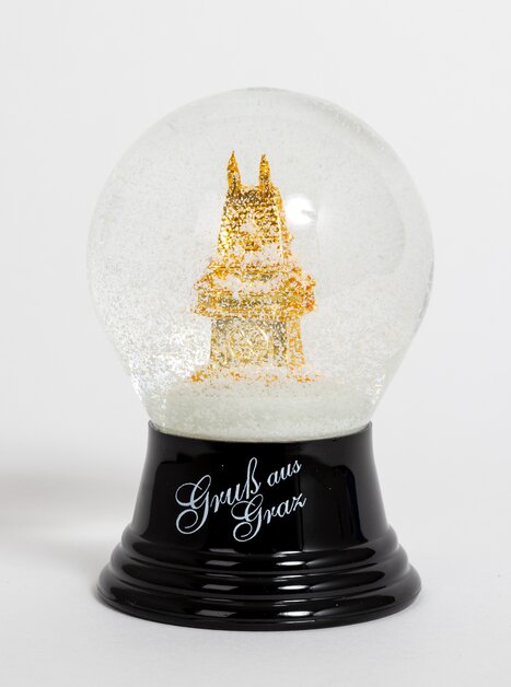 A snow globe displays the Graz Clock Tower with golden glitter. | © Graz Tourismus - Harry Schiffer
