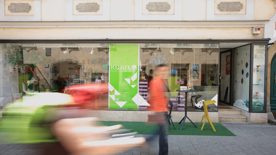 Fassade des Kwirl-Ladens in Graz mit Passanten im Vordergrund. | © Graz Tourismus - Harry Schiffer