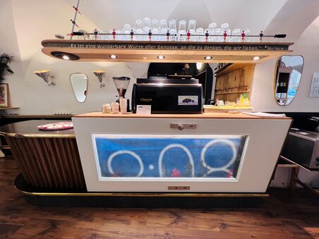 Moderne Café-Theke mit Glasvitrine und ansprechender Dekoration. | © heidenspass