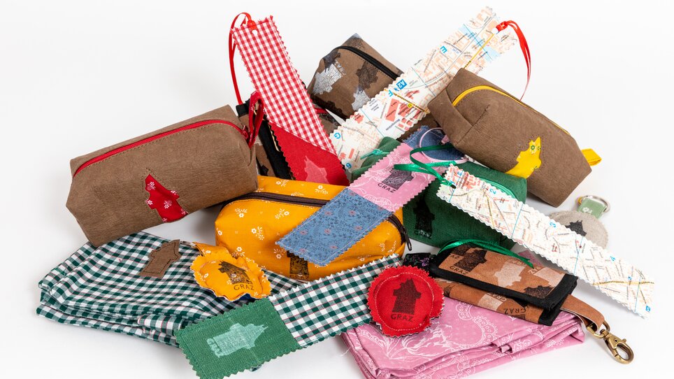 Una varietà di borse, tessuti e accessori con design colorati. | © Graz Tourisus - Harry Schiffer