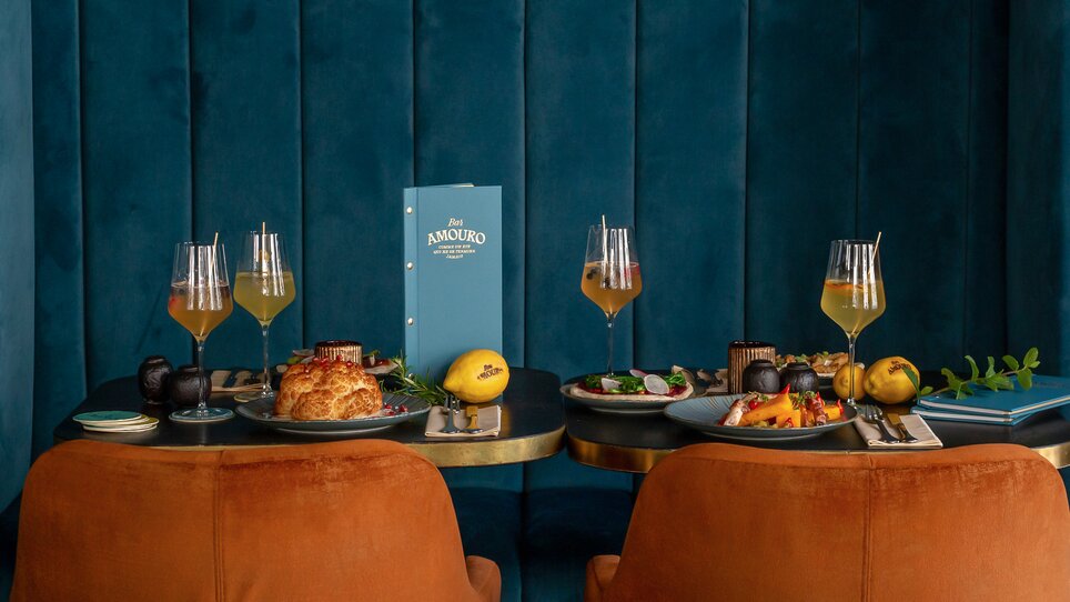 A stylishly set table with various dishes and drinks at Bar Amouro. | © Kristina Sammer