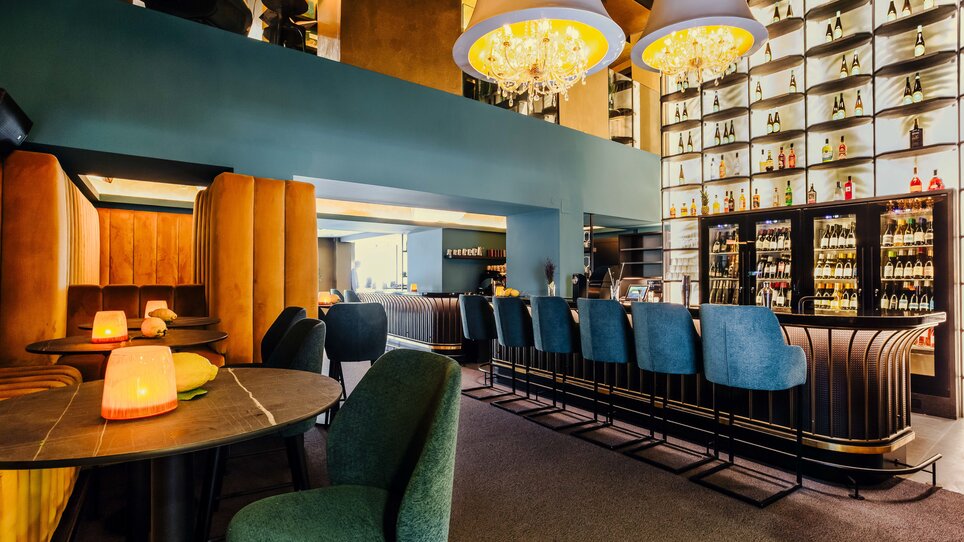 Elegant bar with stylish seating areas and illuminated liquor shelves. | © Simon Bauer