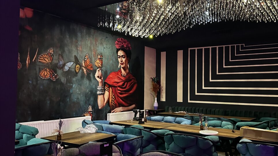 Ristorante elegante con arte murale e posti a sedere accoglienti. | © Bonbon
