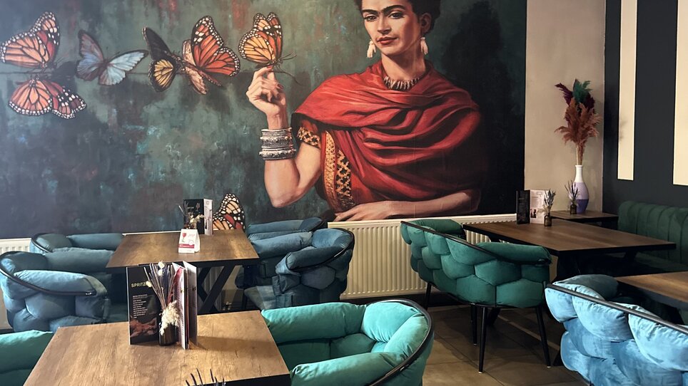 Interno artistico con murales e posti a sedere accoglienti. | © Bonbon