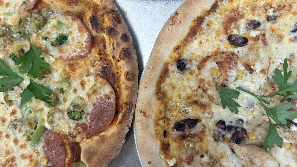 Tre diverse pizze su un tavolo, appena preparate. | © Bonbon