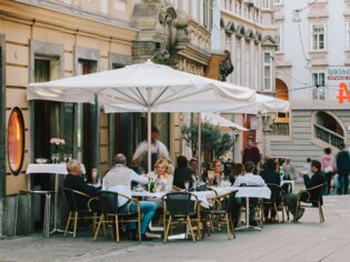 Lebhafte Restaurantterrasse in Graz mit Gästen und Tischen. | © Sebastian Reiser