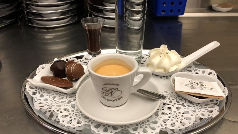 Tasse Espresso, Süßigkeiten und Wasser auf einem Tablett. | © Christian Kober