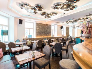 Elegant restaurant interior with stylish furniture and decor. | © dreizehn by Gauster