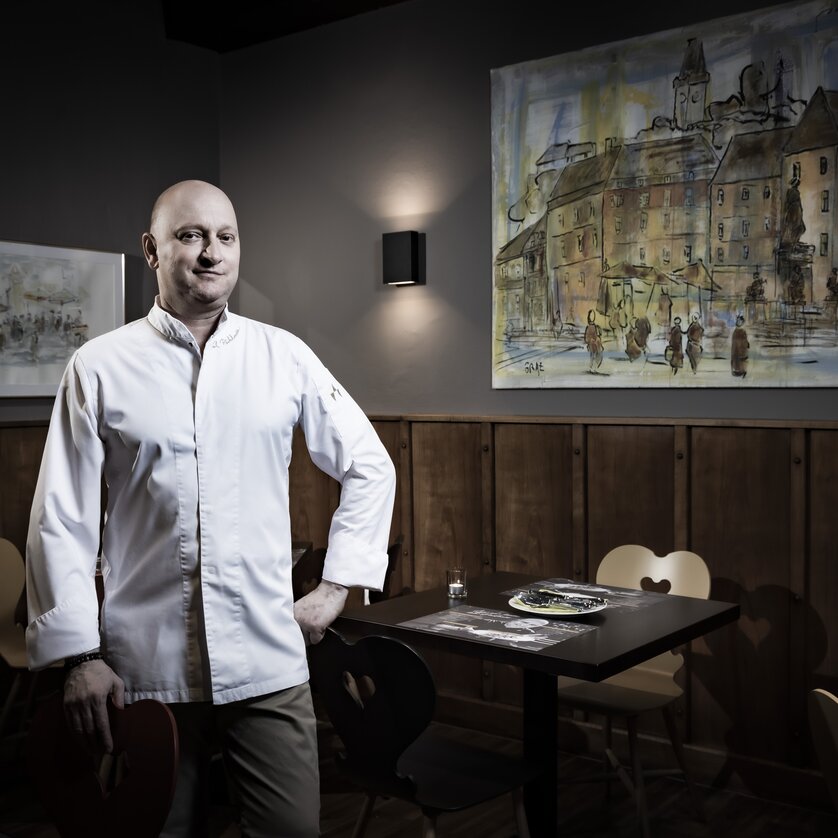 Ferl's Weinstube bei Karli Pichlmaier I Essen & Trinken in Graz | © Graz Tourismus - Werner Krug Ein Koch steht in einem Restaurant mit einem Gemälde im Hintergrund. | © Graz Tourismus - Werner Krug