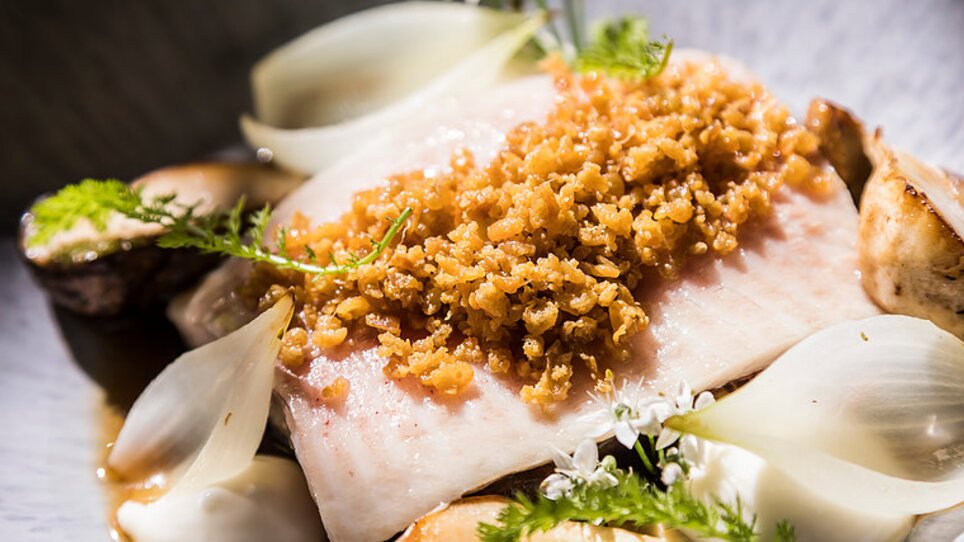 Grilled fish with crunchy topping, served with onions and herbs. | © Genießerei am Markt