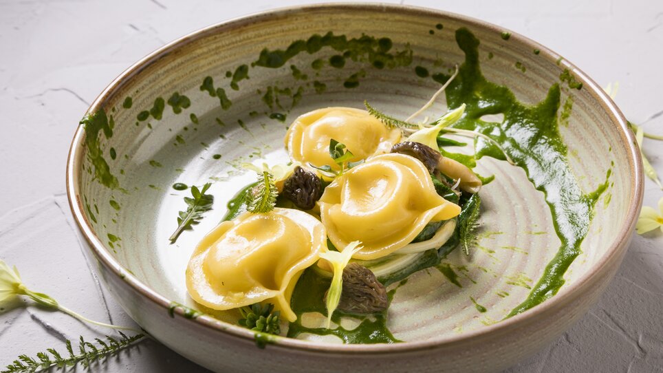 Handmade ravioli with herbs and sauces on a plate. | © Genießerei am Markt