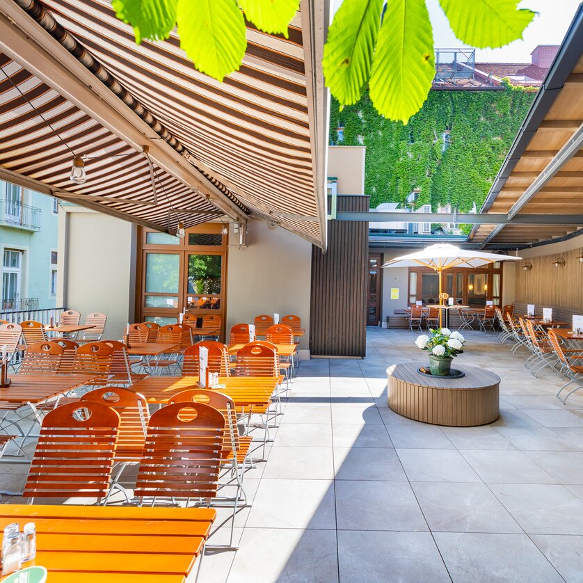 Cozy outdoor area of Gösser Bräu in Graz with wooden chairs and tables. | © Gösser Bräu Graz