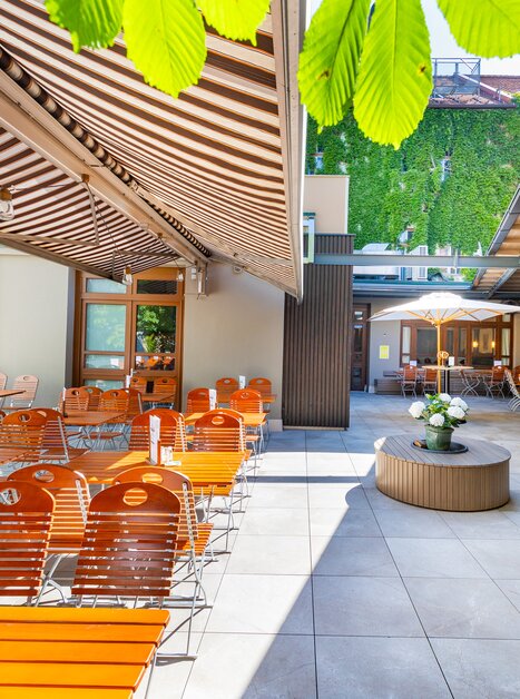 Cozy outdoor area of Gösser Bräu in Graz with wooden chairs and tables. | © Gösser Bräu Graz