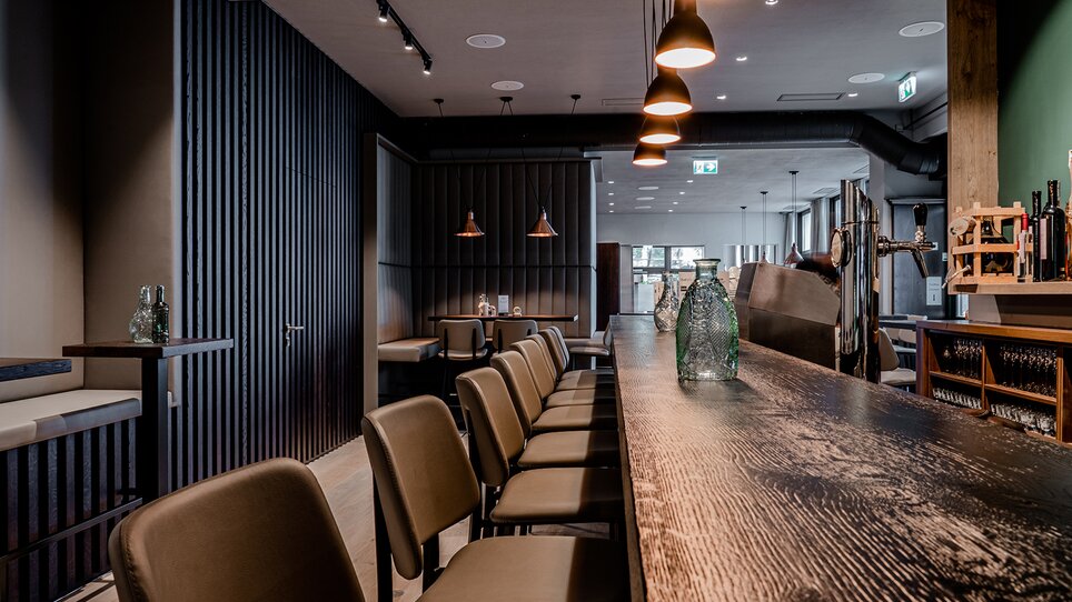 Moderne Bar mit Holztheke und eleganter Beleuchtung. | © Tina Szabo