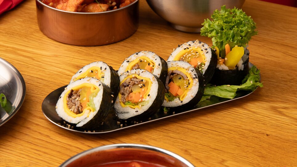 Un piatto di sushi, kimchi, pollo fritto e riso. | © Gogi KG