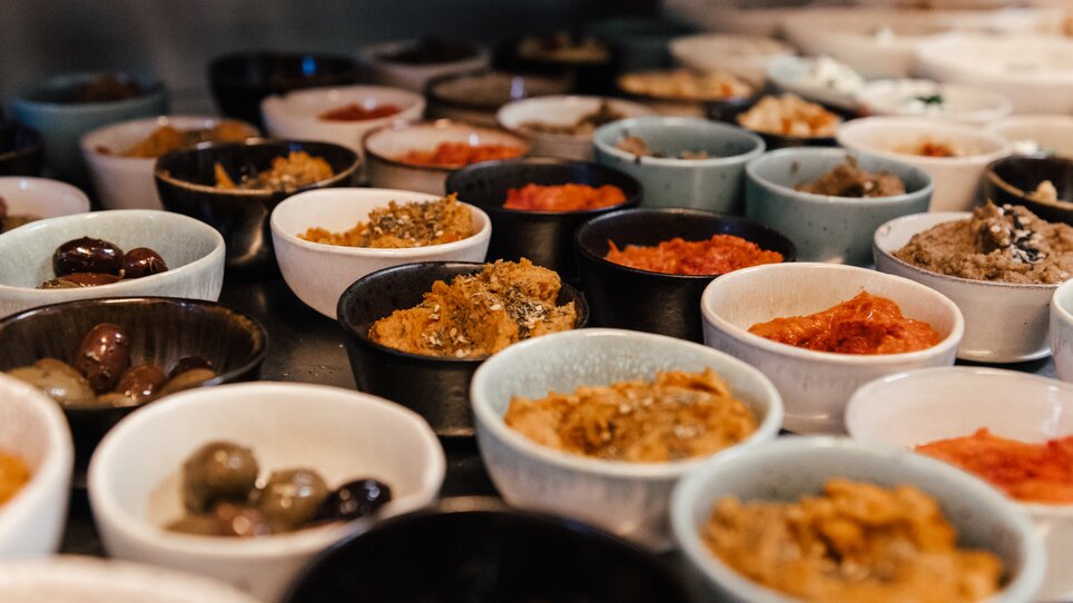 Verschiedene Schalen mit Dips und Antipasti auf einem Tisch. | © Hummel