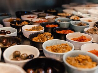 Various bowls with dips and antipasti on a table. | © Hummel