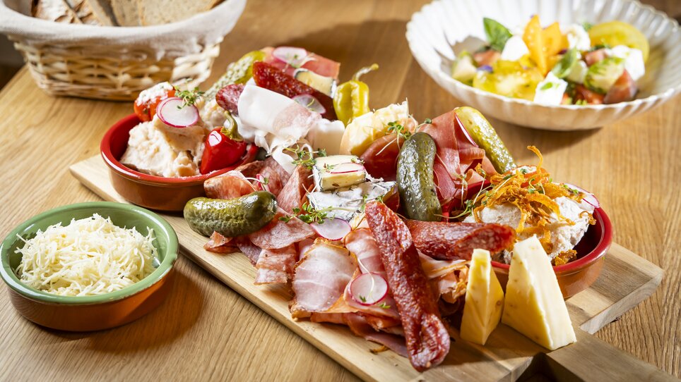 A delicious platter of cured meats and cheeses with sides and salad. | © Kaiser Greissler - Werner Krug