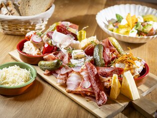 A delicious platter of cured meats and cheeses with sides and salad. | © Kaiser Greissler - Werner Krug