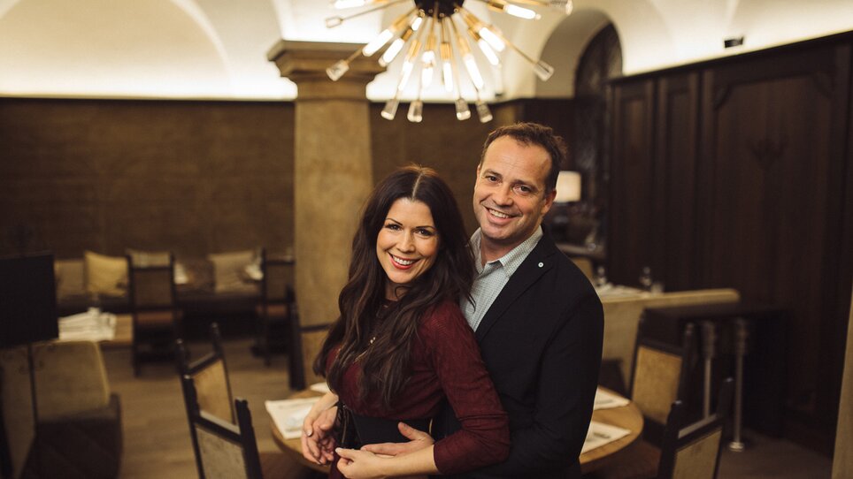 Couple smiling and embracing in an elegant restaurant. | © Landhauskeller