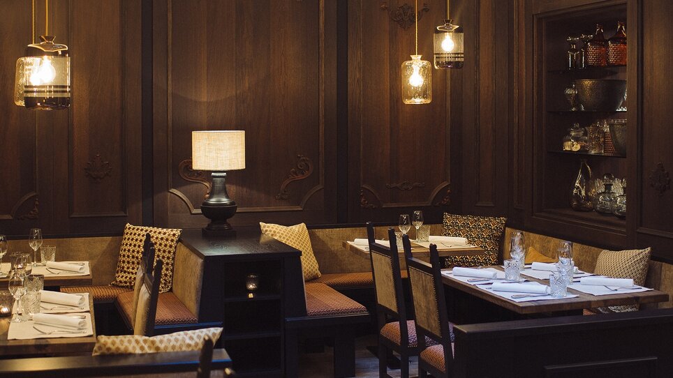 Cozy restaurant with wooden paneling and light fixtures. | © Landhauskeller