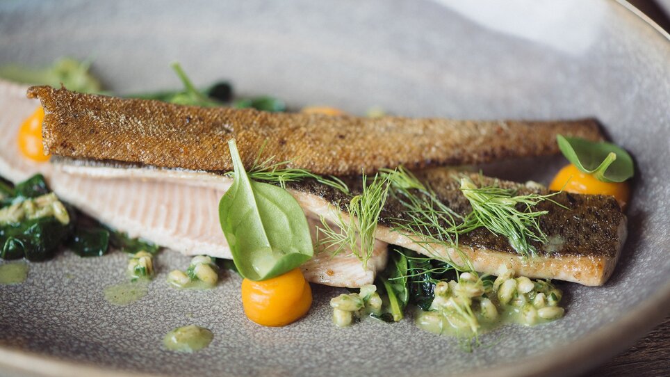 An elegantly arranged fish with sides on a plate. | © Landhauskeller