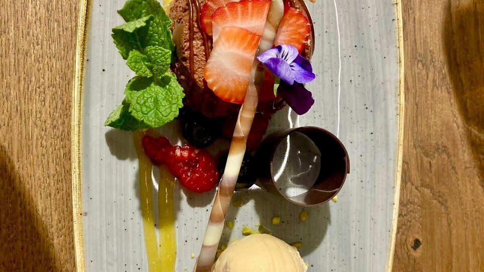 Dessert with chocolate cake, ice cream, fruits, and decoration. | © PUR - die Kochschule Graz
