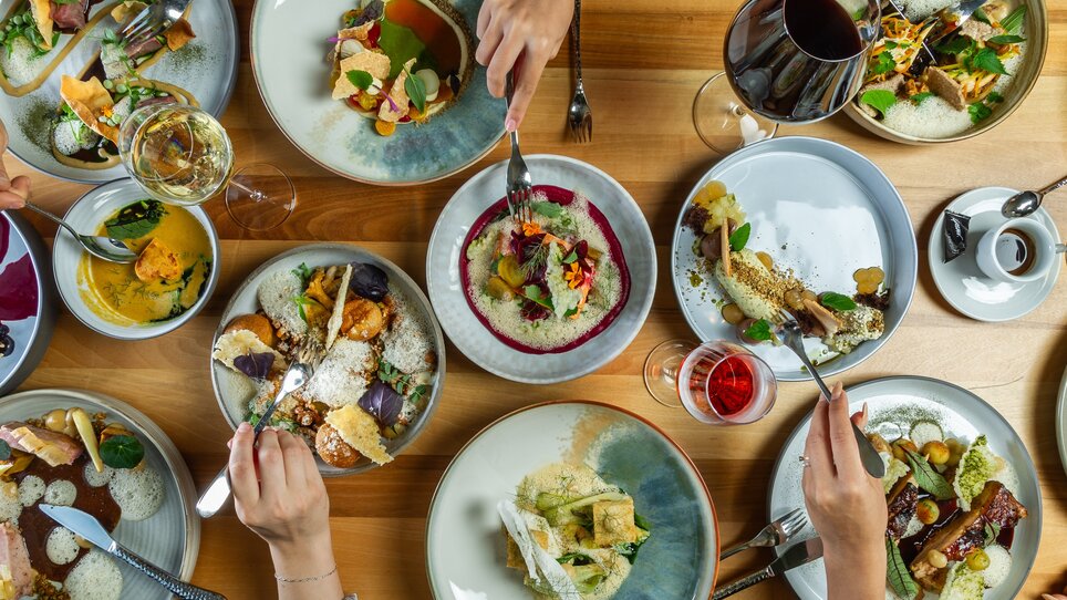 Cibo sociale con una varietà di piatti e bevande. | © Paul Stajan