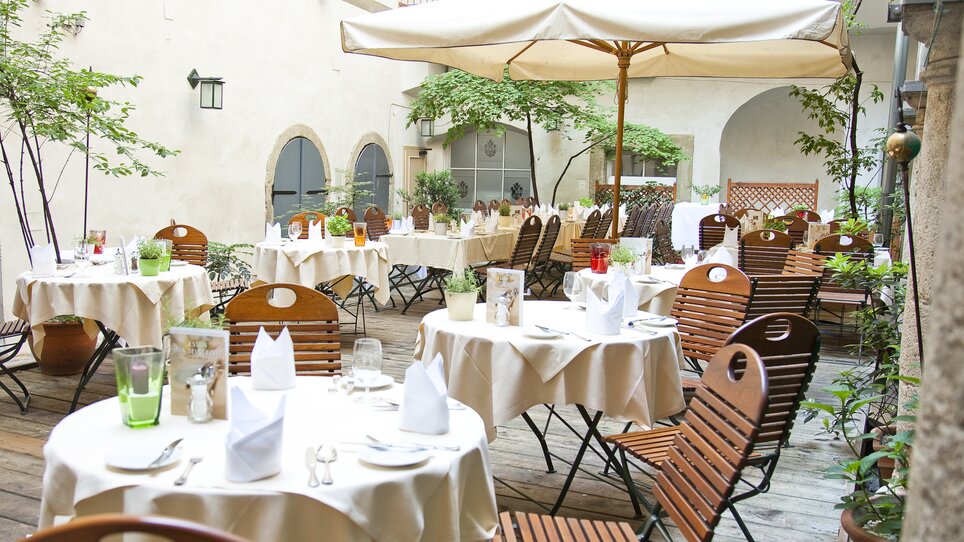Peaceful outdoor area of the tavern with tables and umbrellas. | © Gasthaus Stainzerbauer