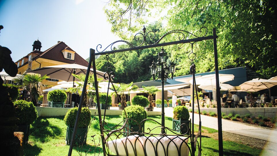 Cozy garden area with swing and sunny atmosphere. | © aiola - Joel Kernasenko