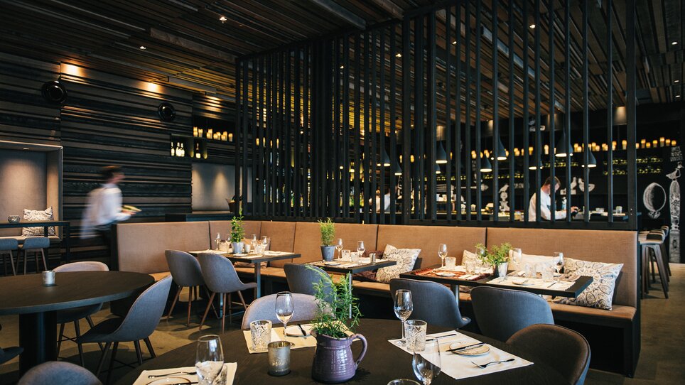 Modern restaurant view with elegant tables and wooden decor. | © aiola - Joel Kernasenko