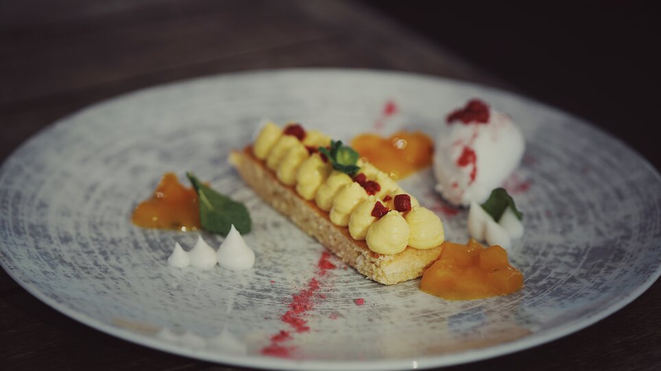 Delicious dessert with cream, fruit gels, and ice cream on a plate. | © aiola