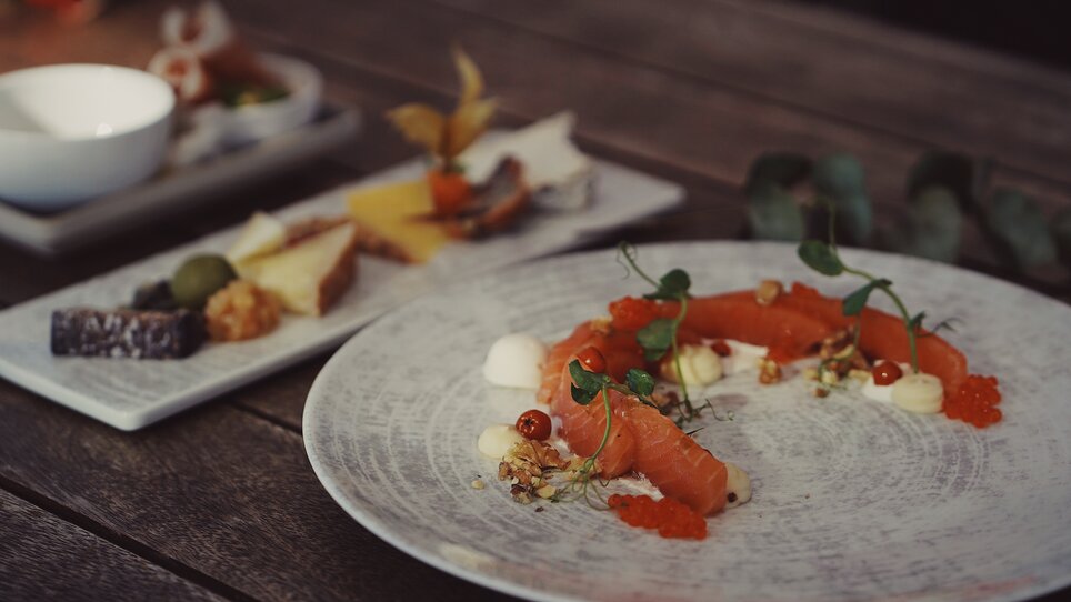 An elegant dish with salmon, caviar, and garnishes. | © aiola