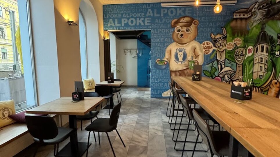 Interno di un ristorante moderno con pareti colorate e tavoli. | © Alpoke - K. van Kerken