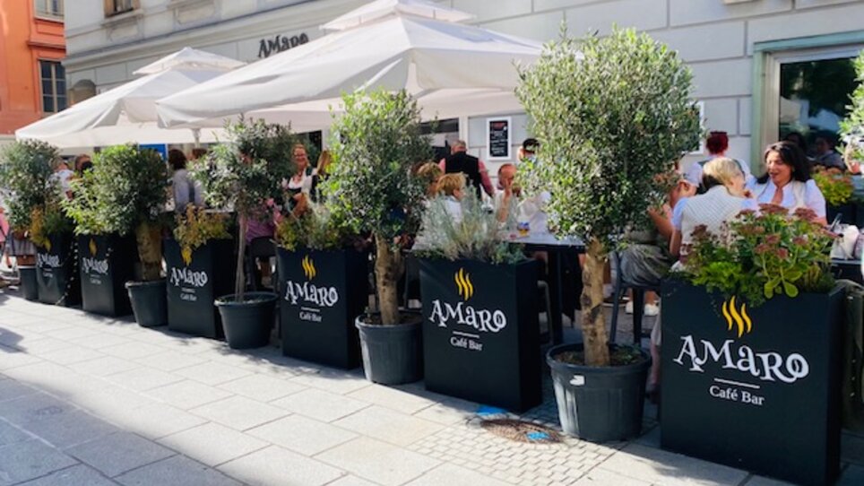 Gemütliches Café mit Pflanzen und Sonnenschirmen in Graz. | © Amaro