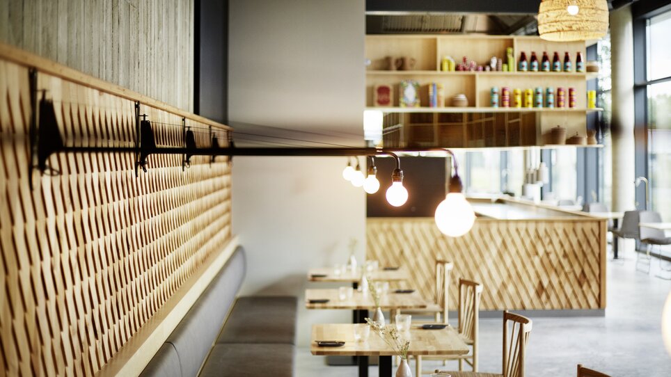 Ristorante moderno con elementi in legno e atmosfera elegante.