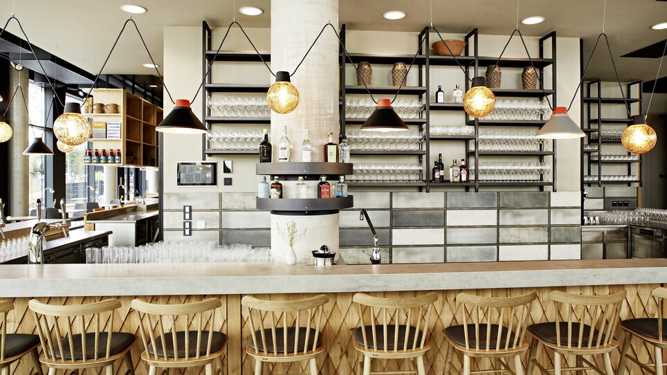 Bar moderna con sedie in legno, design elegante e scaffali.