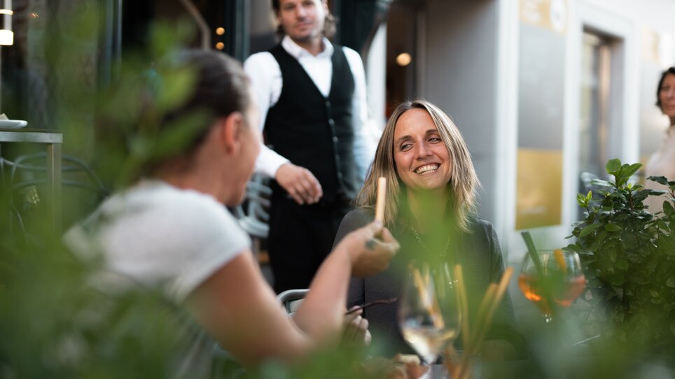 Friends enjoying food and drinks at Auenbrugger Wine Bar. | © Auenbrugger
