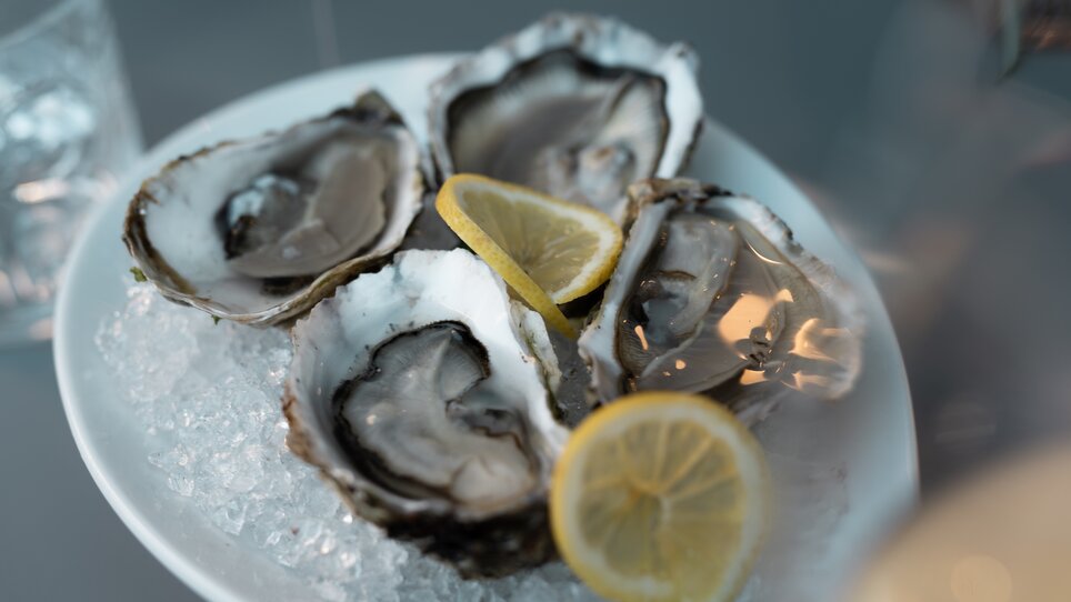 Fresh oysters on ice served with lemon slices. | © Auenbrugger